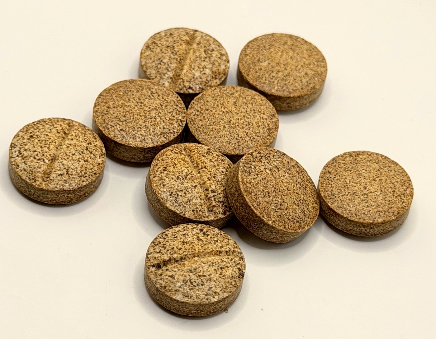 Close up of Live 7 Free whole leaf kratom tablets, each scored down the middle