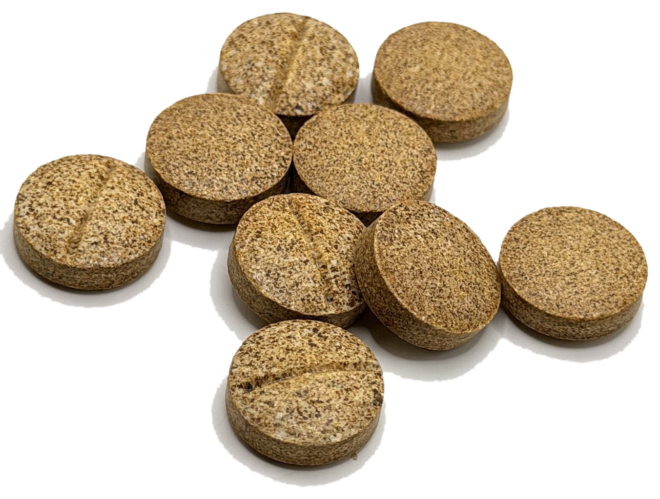 Eight pressed whole leaf kratom tablets, each scored down the middle